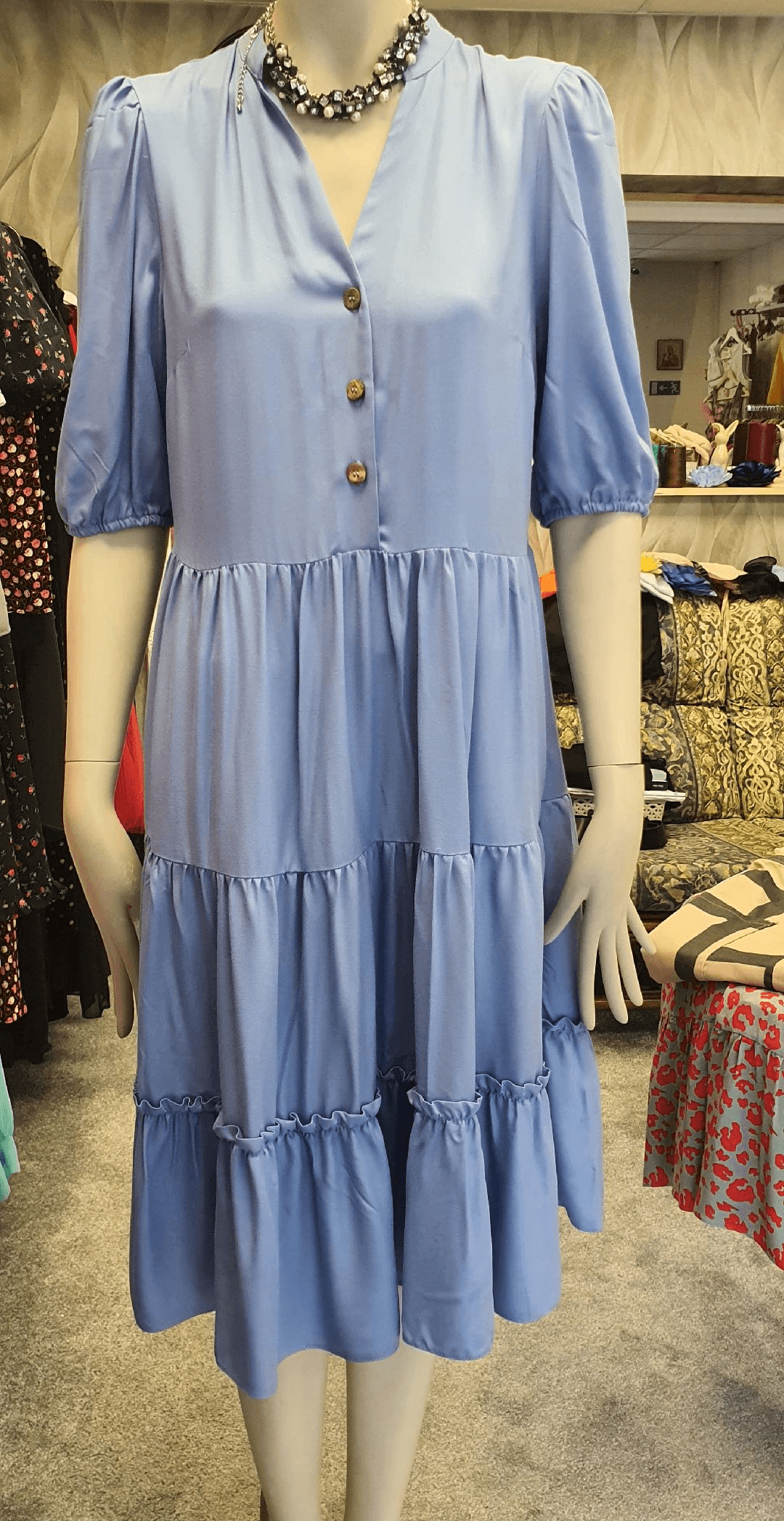 Rochie albastră pe manechin în magazin second-hand.